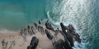 Porównanie wybrzeża wschodniego i zachodniego: które plaże lepsze na pierwszy raz w Australii Skały i turkusowa woda przy plaży Currumbin na wschodnim wybrzeżu Australii